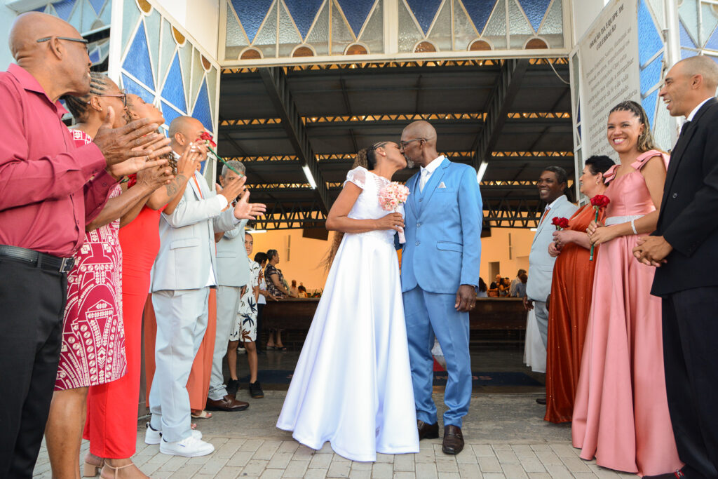 Noivos saindo da igreja em tunel pelos padrinhos.