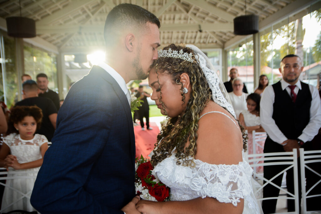 Noivo beijando testa da noiva durante o casamento